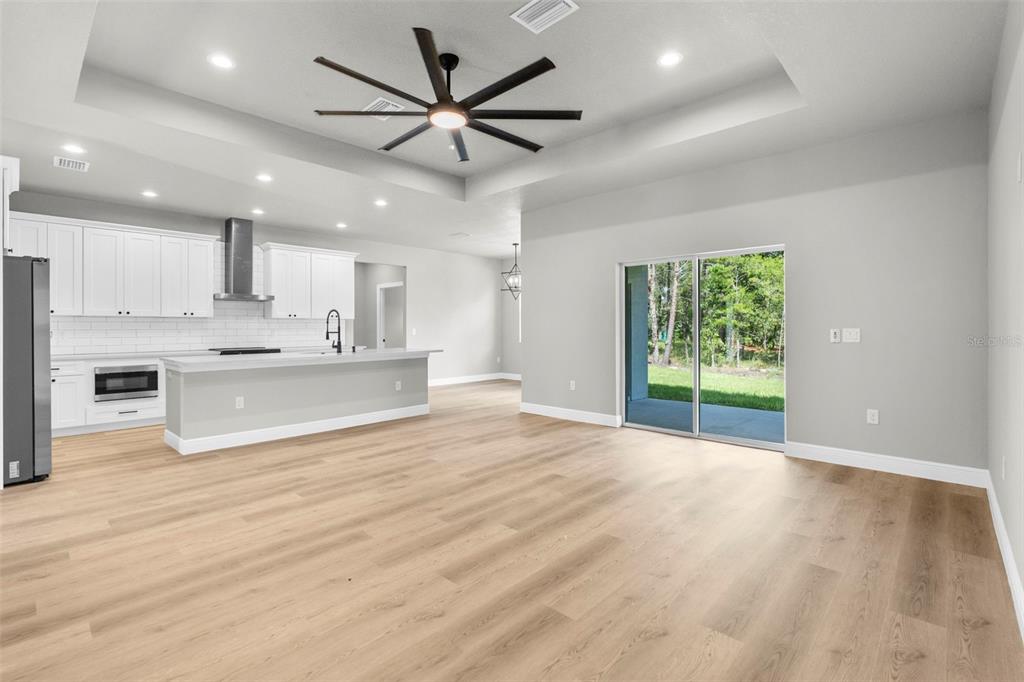3 Lupine Street Homosassa, FL 34446 - Photo 3 of 44 a view of an empty room with kitchen appliances and a ceiling fan