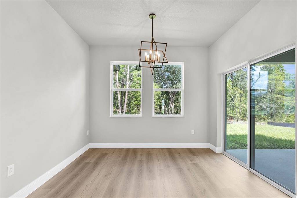 3 Lupine Street Homosassa, FL 34446 - Photo 9 of 44 a view of an empty room with wooden floor and a window