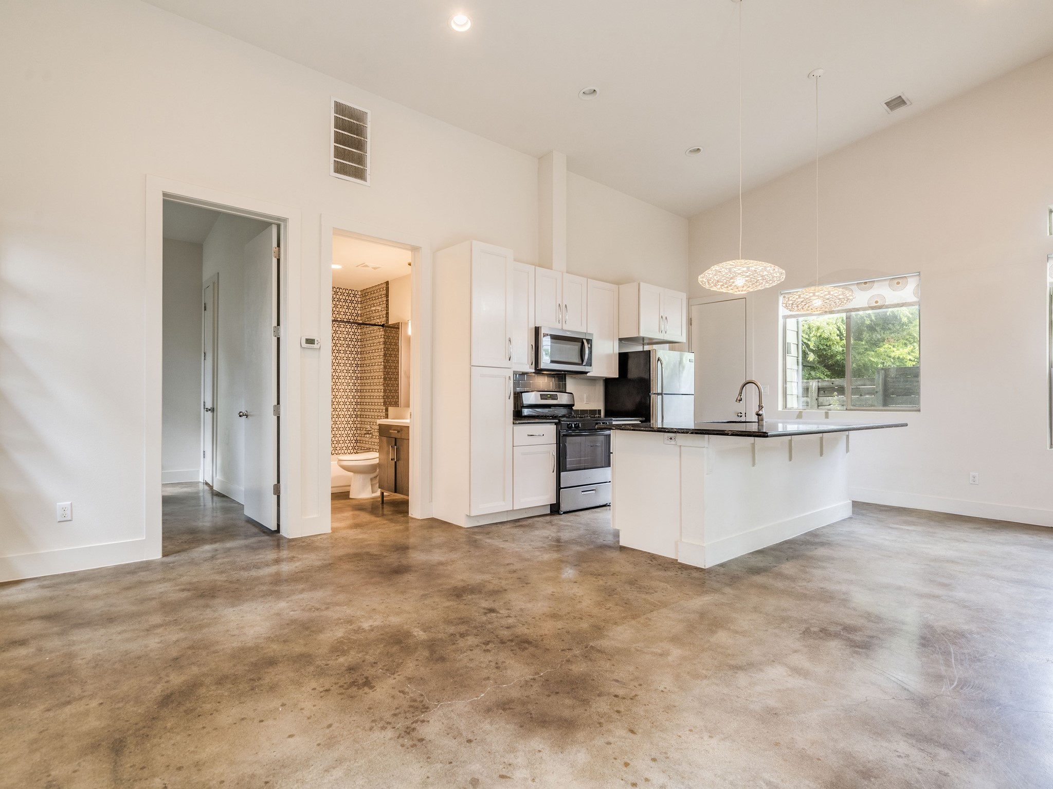 1404 Singleton Avenue, Unit B Austin, TX 78702 - Photo 7 of 21 An inviting open-concept kitchen and living area features a convenient island and high ceilings.