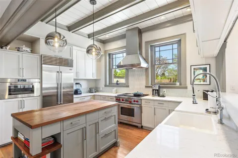 a kitchen with stainless steel appliances granite countertop a sink a stove and cabinets