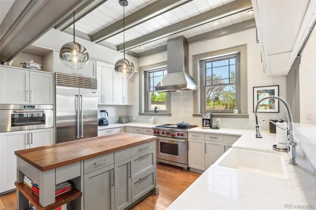 a kitchen with stainless steel appliances granite countertop a sink a stove and cabinets
