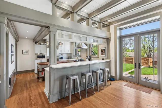 a large white kitchen with lots of counter space and glass door