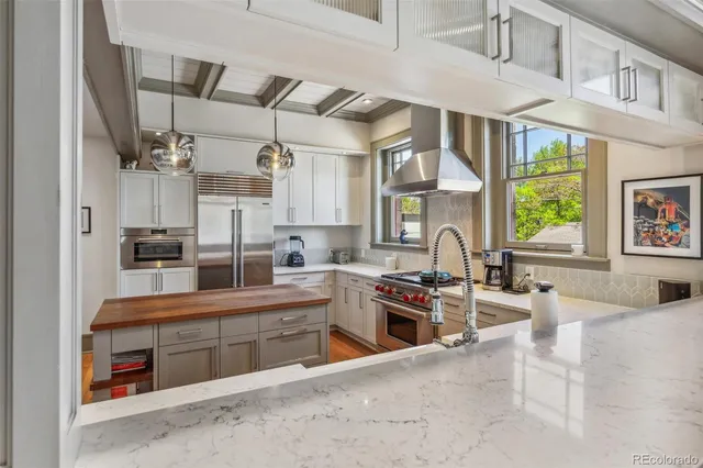 a kitchen with stainless steel appliances kitchen island granite countertop a stove and a sink
