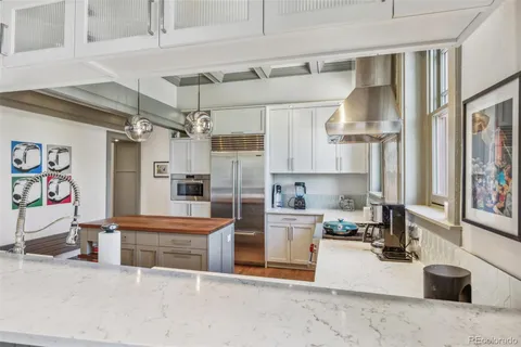 a kitchen with stainless steel appliances granite countertop a sink and a refrigerator