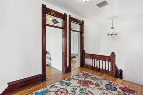 a view of a hallway with wooden floor and a bedroom