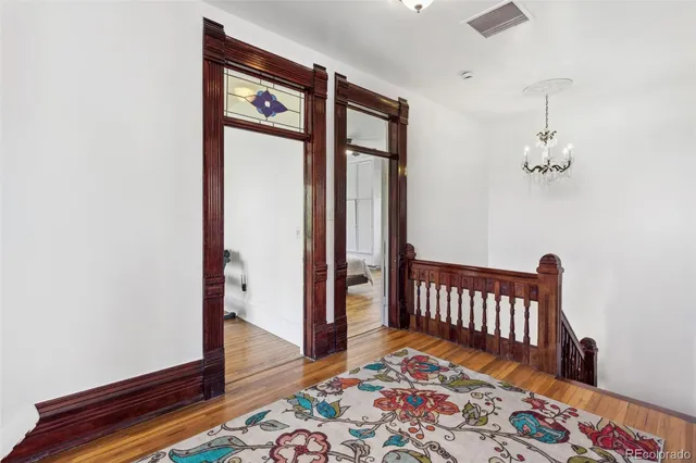 a view of a hallway with wooden floor and a bedroom