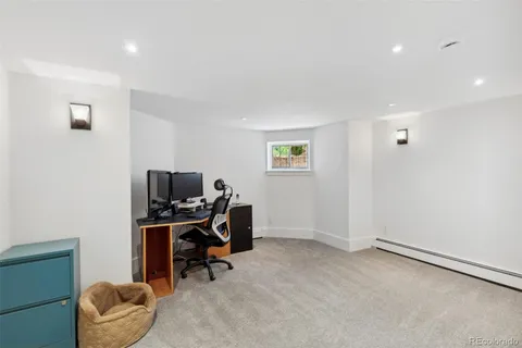 a view of a workspace with furniture and a window