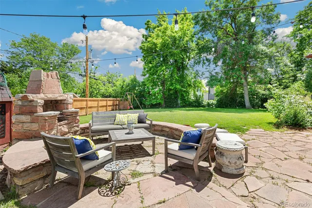 a view of a patio with lawn chairs and couches with wooden floor and plants