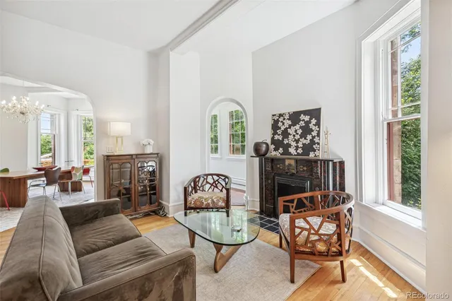 a living room with furniture a fireplace and a floor to ceiling window