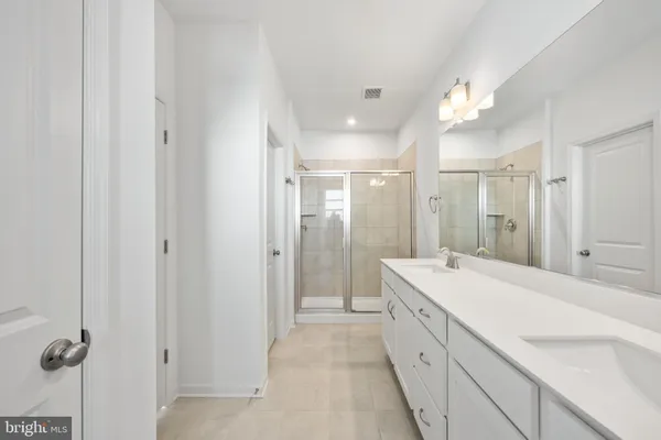 a spacious bathroom with a double vanity sink a mirror and a bathtub