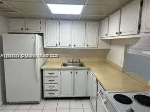 a kitchen with granite countertop cabinets and white appliances