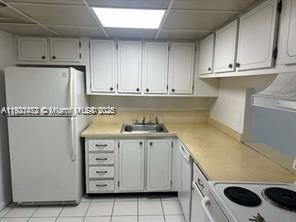 500 Executive Center Drive, Unit 1C West Palm Beach, FL 33401 - Photo 3 of 12 a kitchen with granite countertop cabinets and white appliances