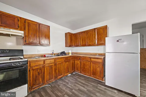 a kitchen with stainless steel appliances granite countertop wooden cabinets sink and a granite counter top