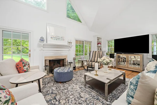 a living room with furniture a fireplace and a flat screen tv