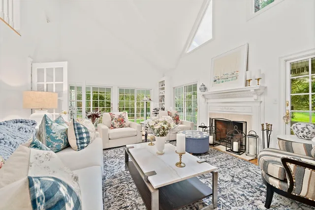 a living room with furniture fireplace and a large window
