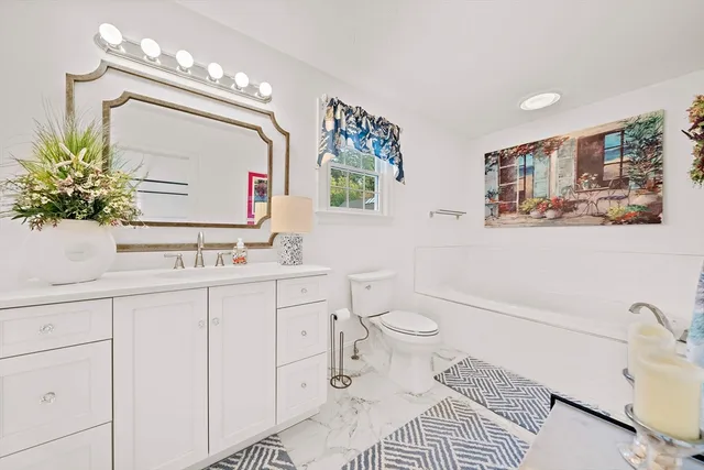 a bathroom with a sink a toilet and mirror