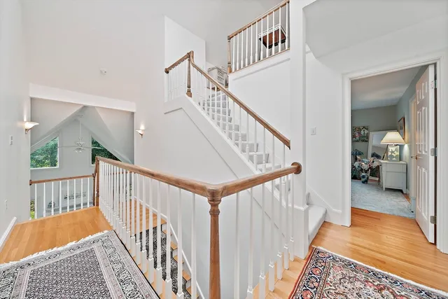 a view of staircase with railing and a rug