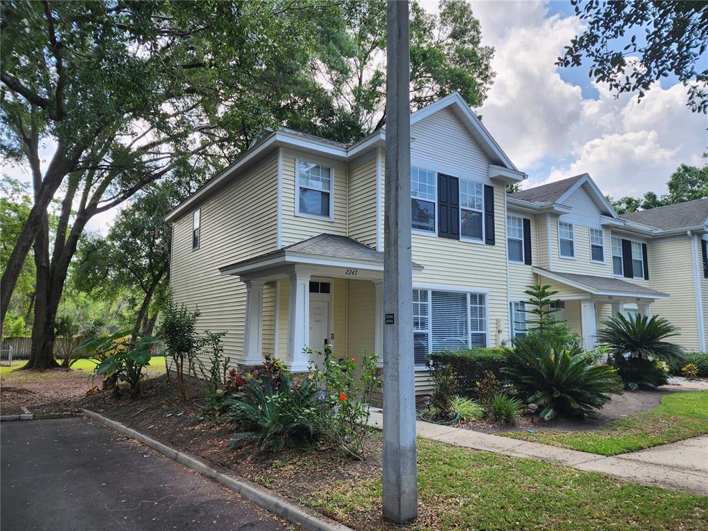 a front view of a house with a yard and potted plants