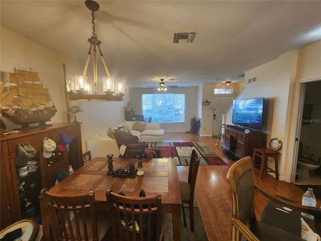 a view of a dining room with furniture a kitchen and chandelier