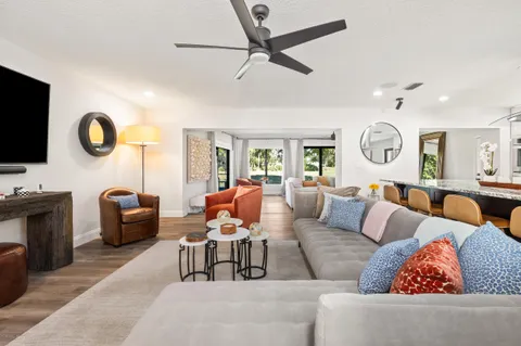 a living room with furniture kitchen view and a window