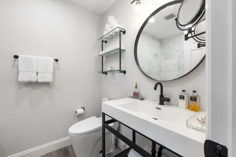a bathroom with a sink toilet and a mirror
