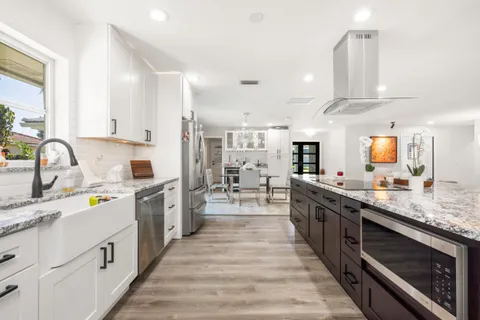 a large kitchen with stainless steel appliances lots of counter space and a sink