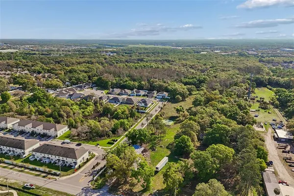 an aerial view of residential houses with outdoor space and trees