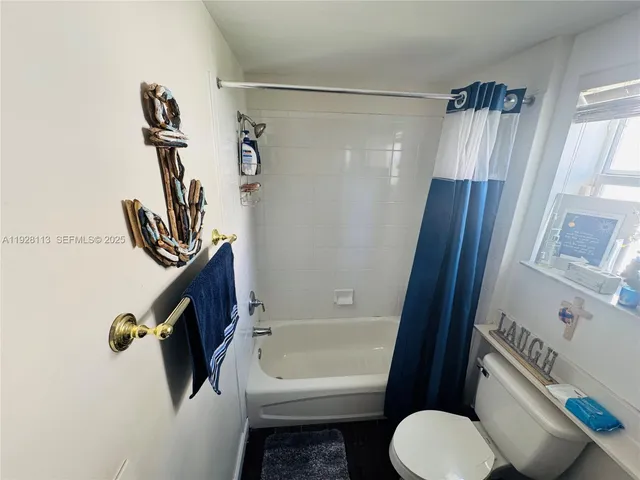 a bathroom with a shower a toilet a sink and mirror