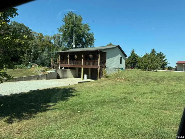a view of a house with a yard and a large tree