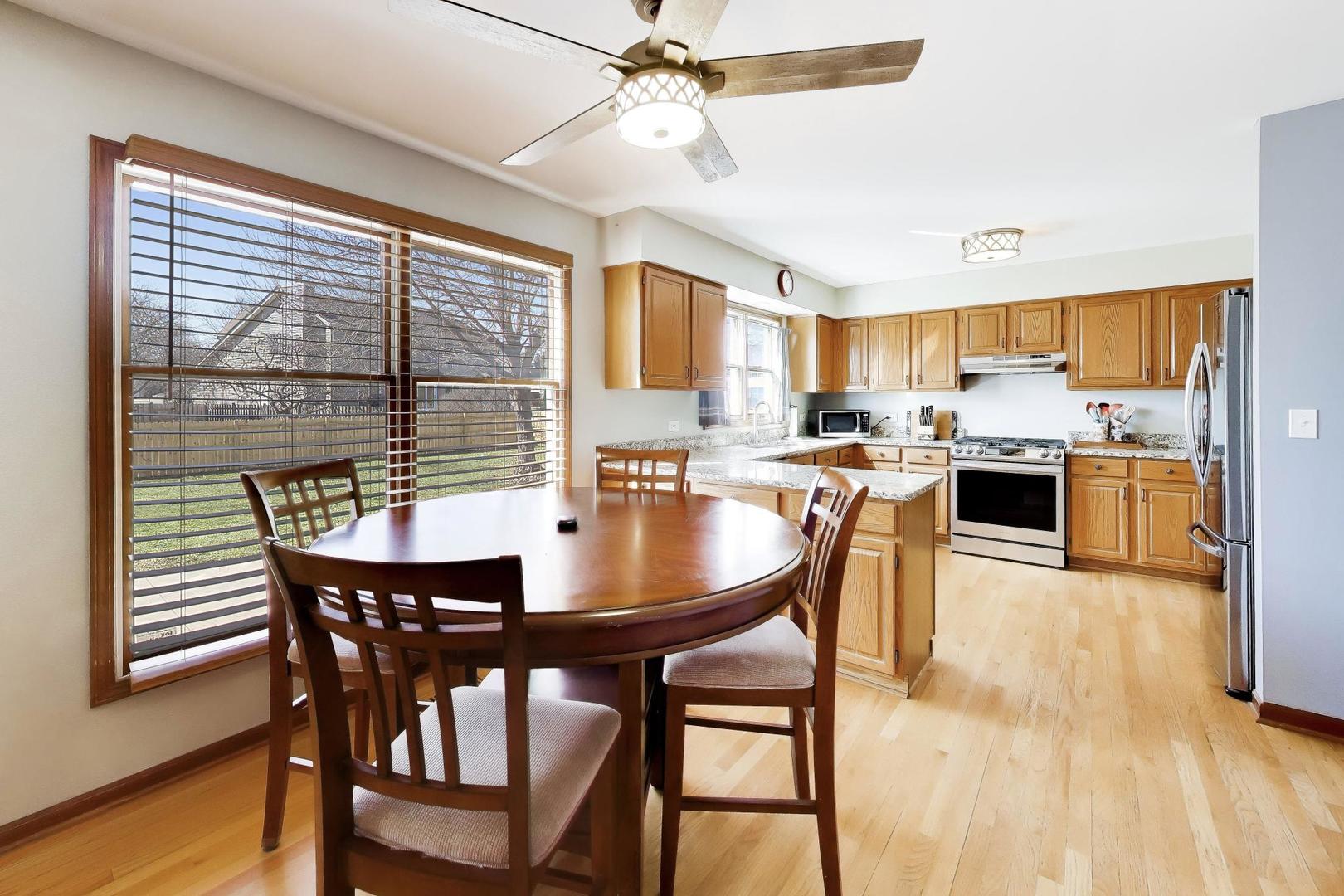 850 Tartans Drive West Dundee, IL 60118 - Photo 16 of 49 a dining room with a table chairs and a kitchen view