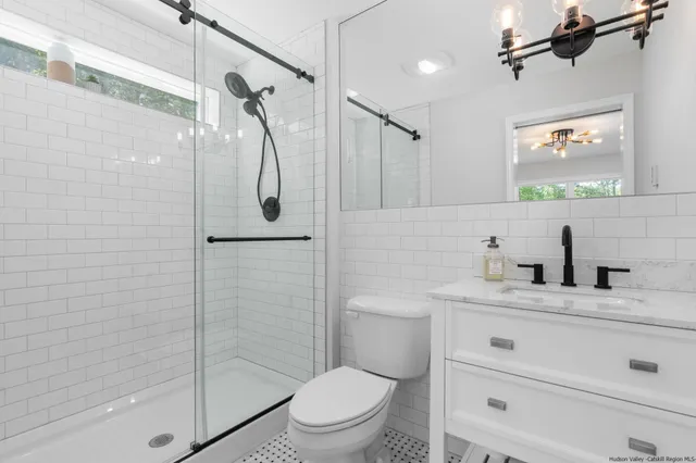 a bathroom with a granite countertop sink toilet and shower