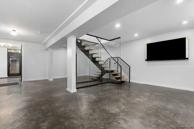 an empty room with windows and flat screen tv