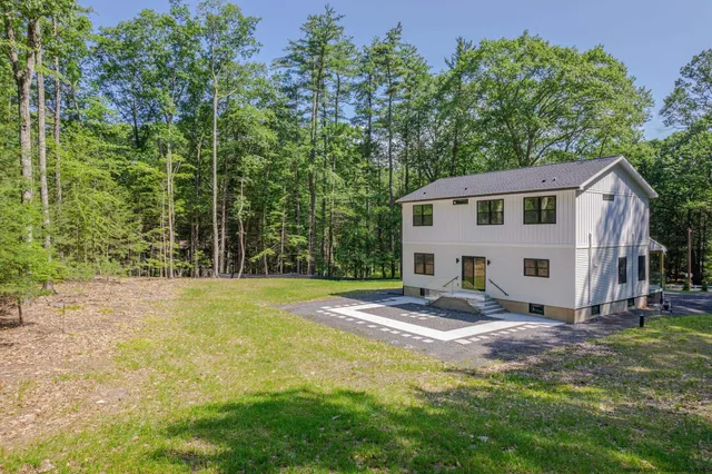 a view of a house with backyard and trees
