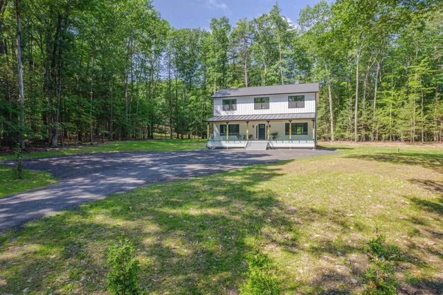 a view of a house with a yard and sitting area