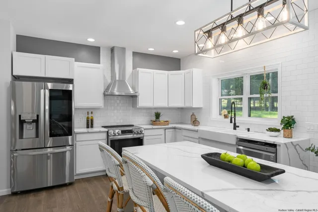 a kitchen with a sink a counter top space stainless steel appliances and cabinets