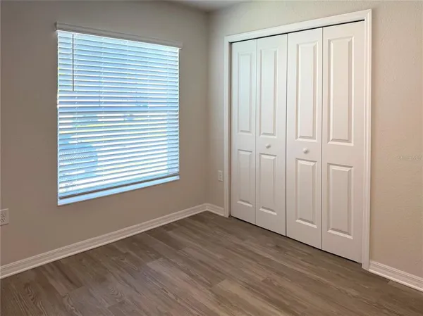 an empty room with wooden floor and a window