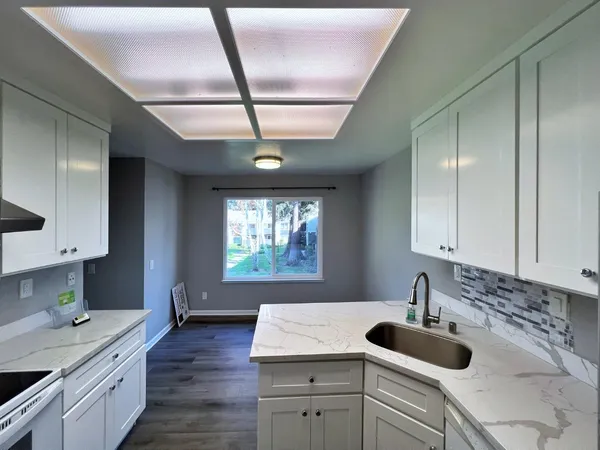 a kitchen with sink cabinets and wooden floor