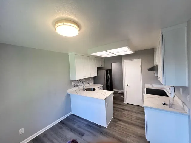 a kitchen with a sink cabinets and wooden floor