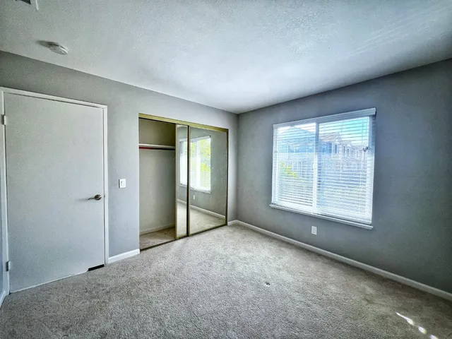an empty room with windows and closet