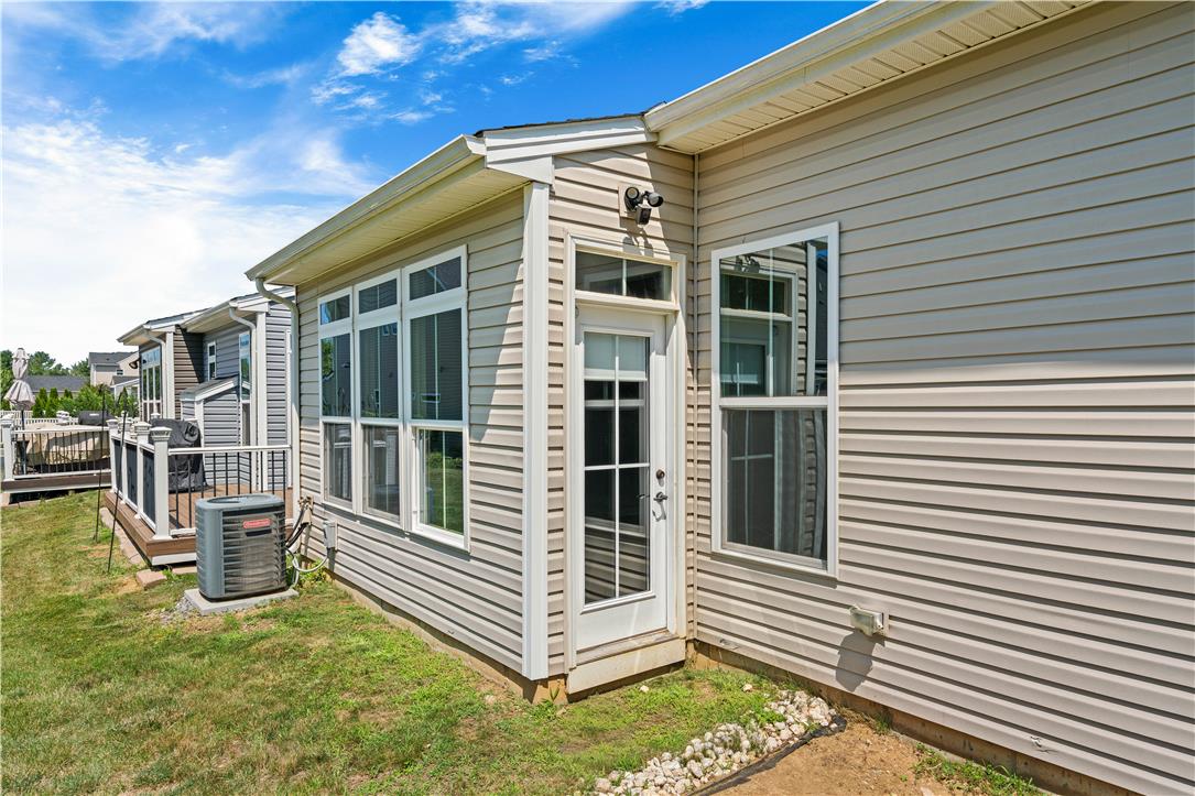 4758 Rafi Road Easton, PA 18045 - Photo 50 of 55 A well-maintained side exterior showcases a glass-paned door, multiple windows, and neatly kept landscaping.