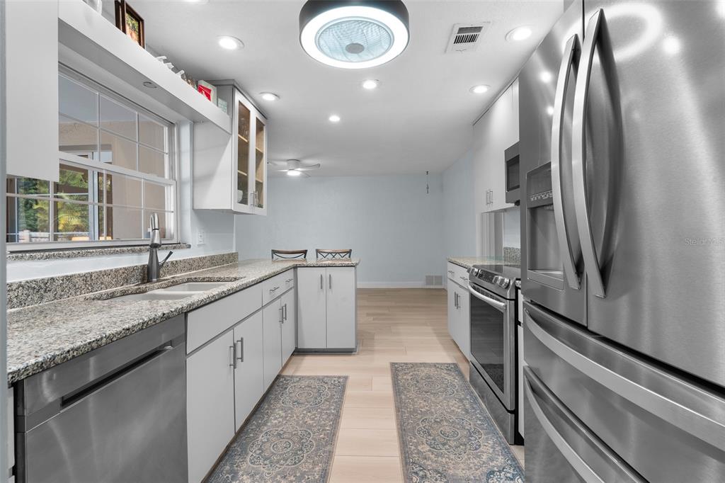 603 Ruskin Road Clearwater, FL 33765 - Photo 12 of 41 a large kitchen with kitchen island a sink stainless steel appliances and cabinets