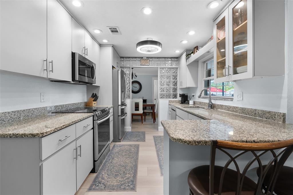 603 Ruskin Road Clearwater, FL 33765 - Photo 13 of 41 a large kitchen with stainless steel appliances granite countertop a sink and a white cabinets