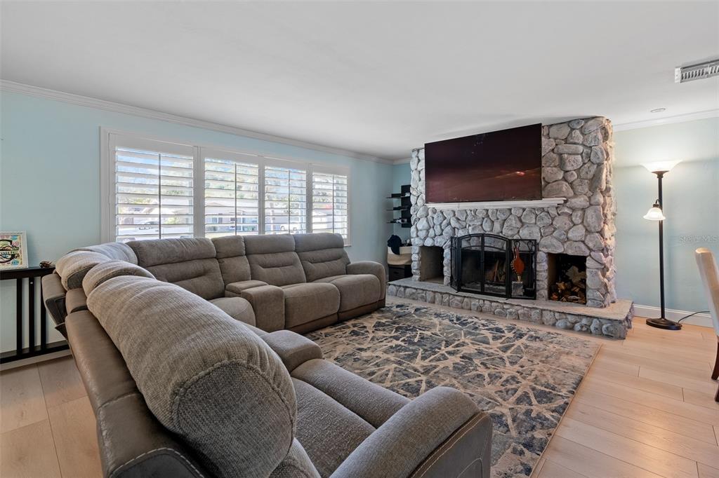 603 Ruskin Road Clearwater, FL 33765 - Photo 8 of 41 a living room with furniture a flat screen tv and a fireplace
