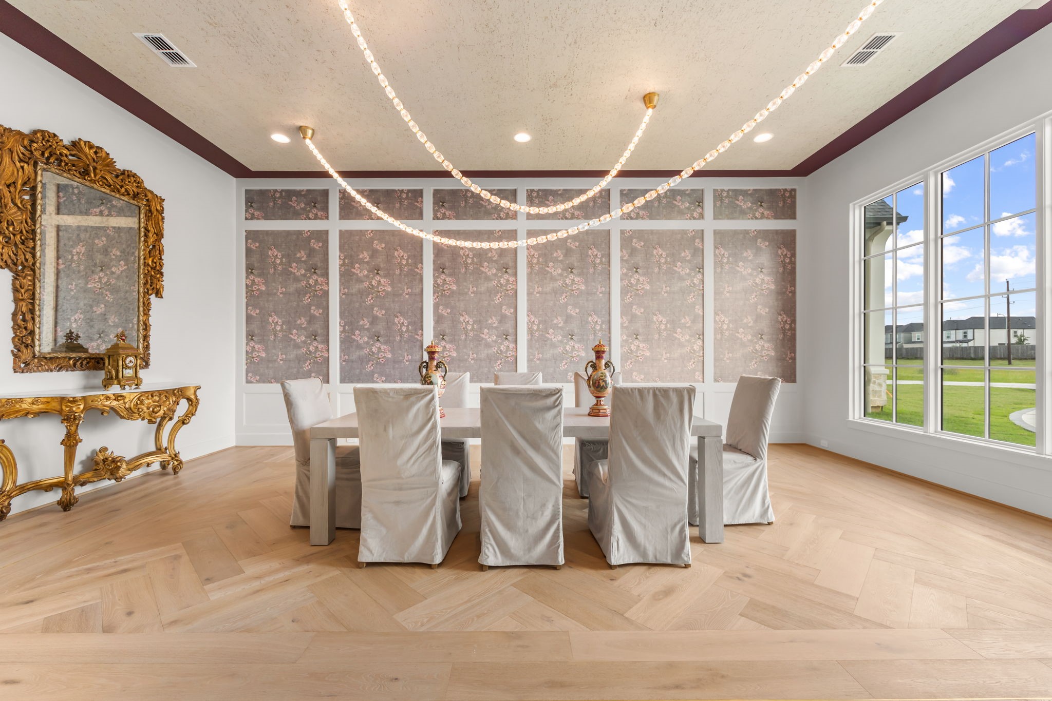 4233 Two Gun Way Katy, TX 77494 - Photo 8 of 47 Large banquet sized formal dining room with rug pattern in hardwood floors and unique strands of crystal with gold accented light fixture.