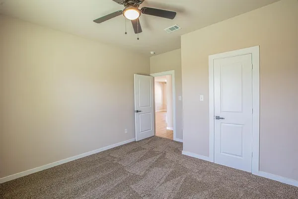 an empty room with a ceiling fan and a window