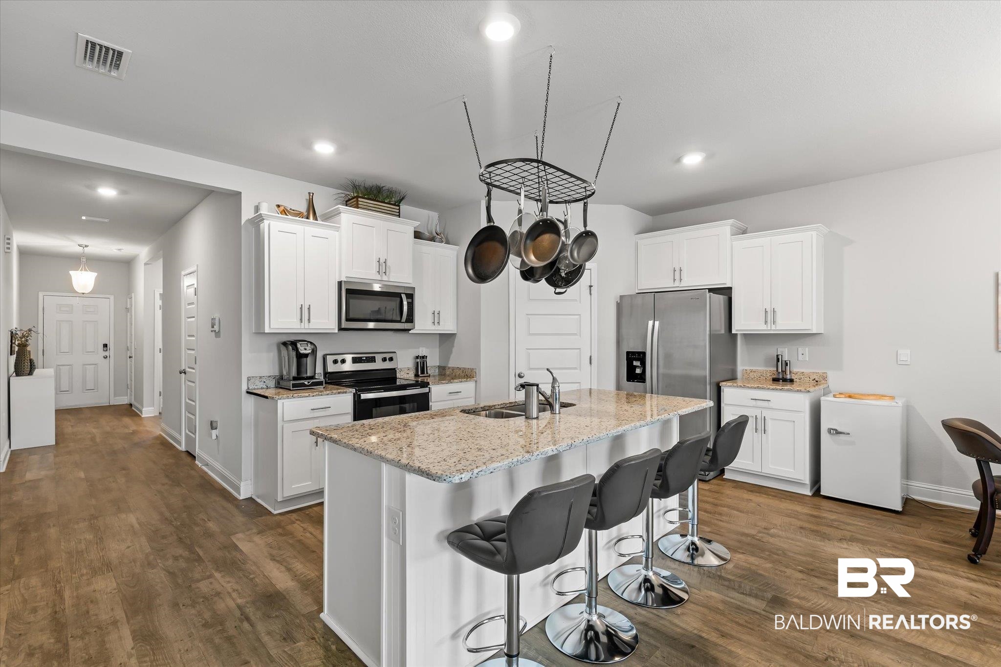 23246 Lieutenant Avenue Foley, AL 36535 - Photo 11 of 36 Kitchen with sink, a breakfast bar area, white cabinetry, a center island with sink, and stainless steel appliances
