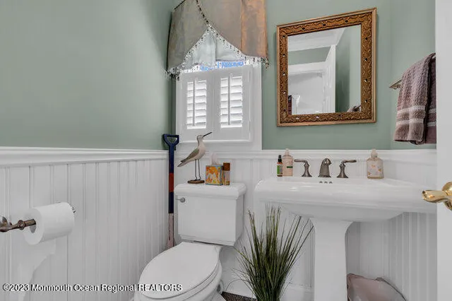 a bathroom with a sink a toilet and mirror