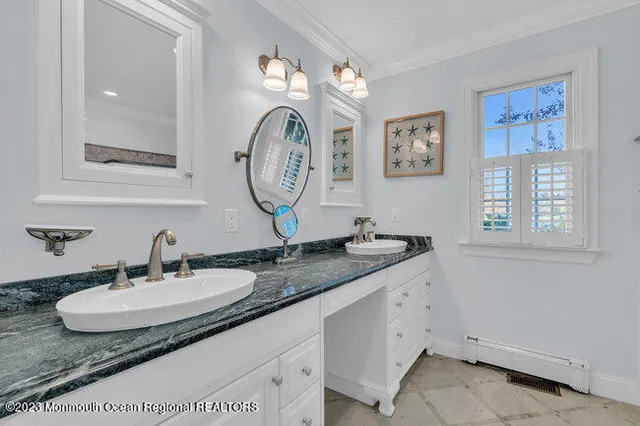 a bathroom with a granite countertop double vanity sinks and a mirror