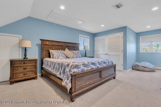 809 Lake Drive Spring Lake, NJ 07762 - Photo 26 of 34 a spacious bedroom with a bed and a lamp