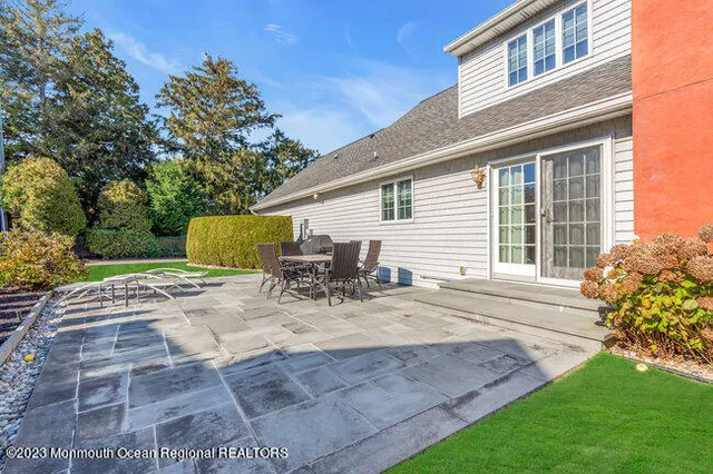 a view of a house with backyard and sitting area